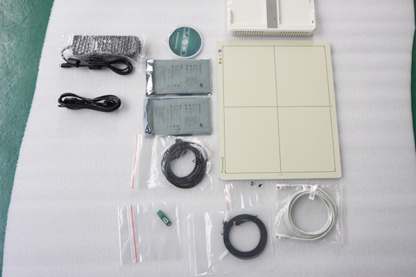 Flat panel detector kit with power supply, batteries, and network cables laid out for installation